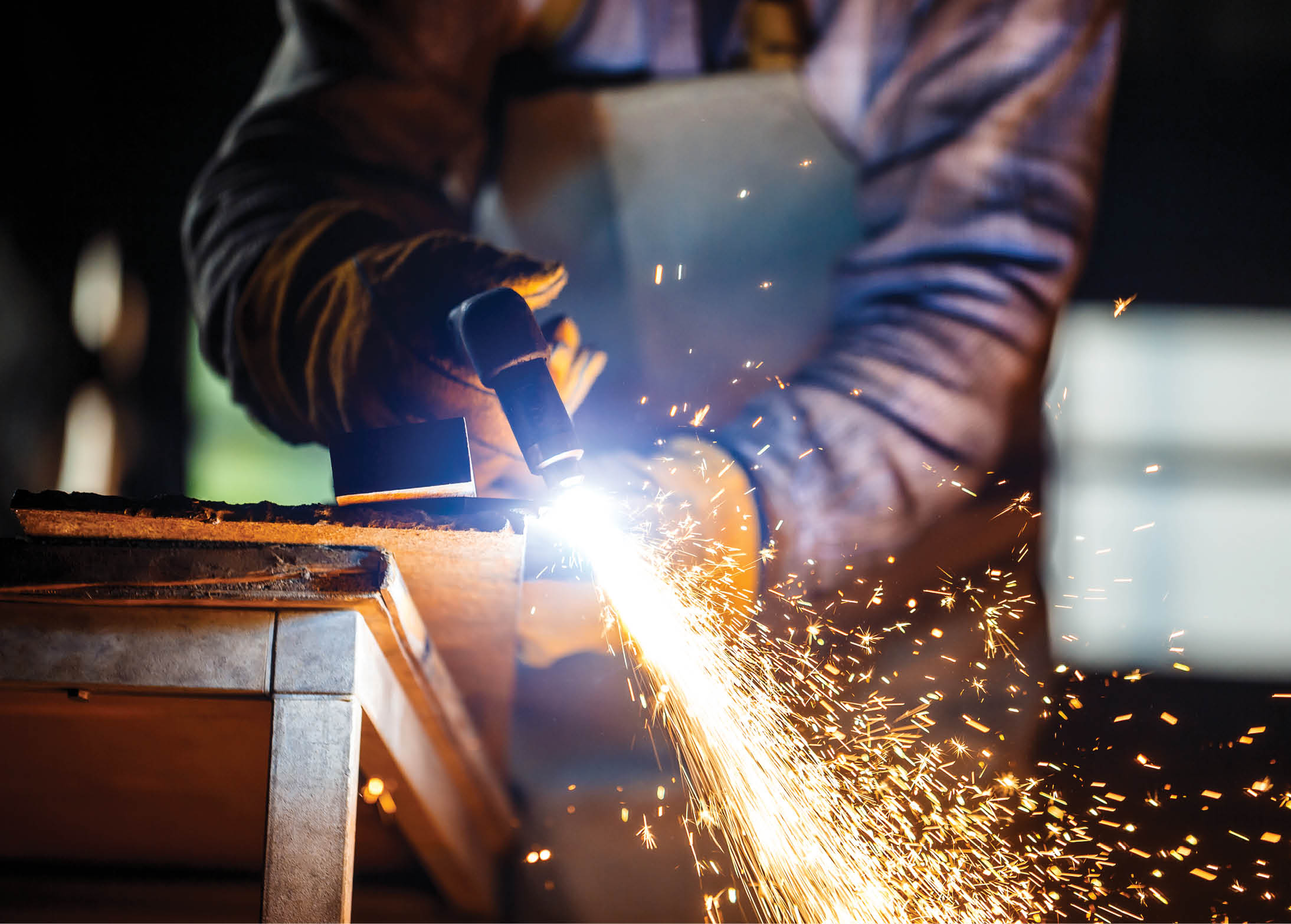 Worker cutting metal with plasma equipment on plant 